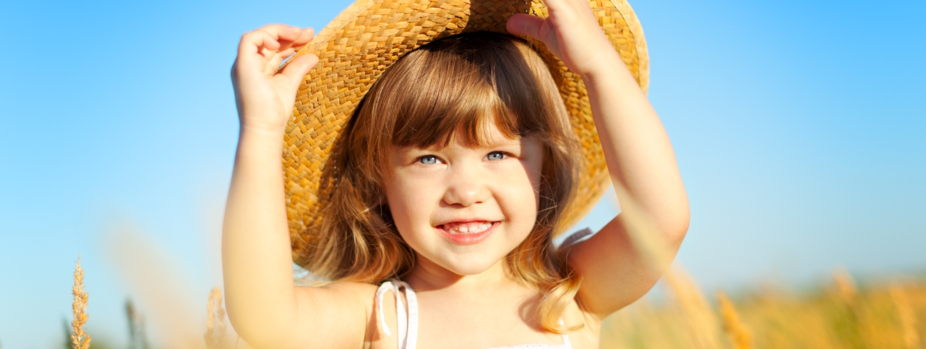 Girl in straw hat Pediatric Dentist Dr. Rex Wildey in Kerrville, TX.